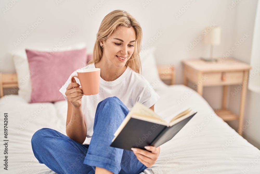 Young blonde woman drinking cup of coffee reading book at bedroom Young blonde woman drinking cup of coffee reading book at bedroom