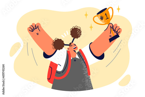 Schoolgirl with golden cup celebrates victory in school olympiad and raises hands up