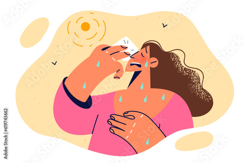 Woman with heatstroke wipes sweat from face due to sharp warming associated with climate change