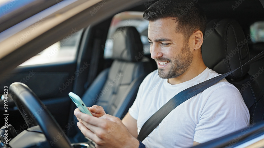 Young hispanic man using smartphone sitting on car at street Young hispanic man using smartphone sitting on car at street