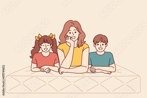 Mother and children lie on mattress recommending use of high-quality and comfortable furniture for bedroom and sleep. Happy woman together with kids with mattress for healthy rest after hard day