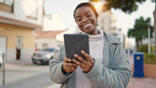 African american woman smiling confident using touchpad at street