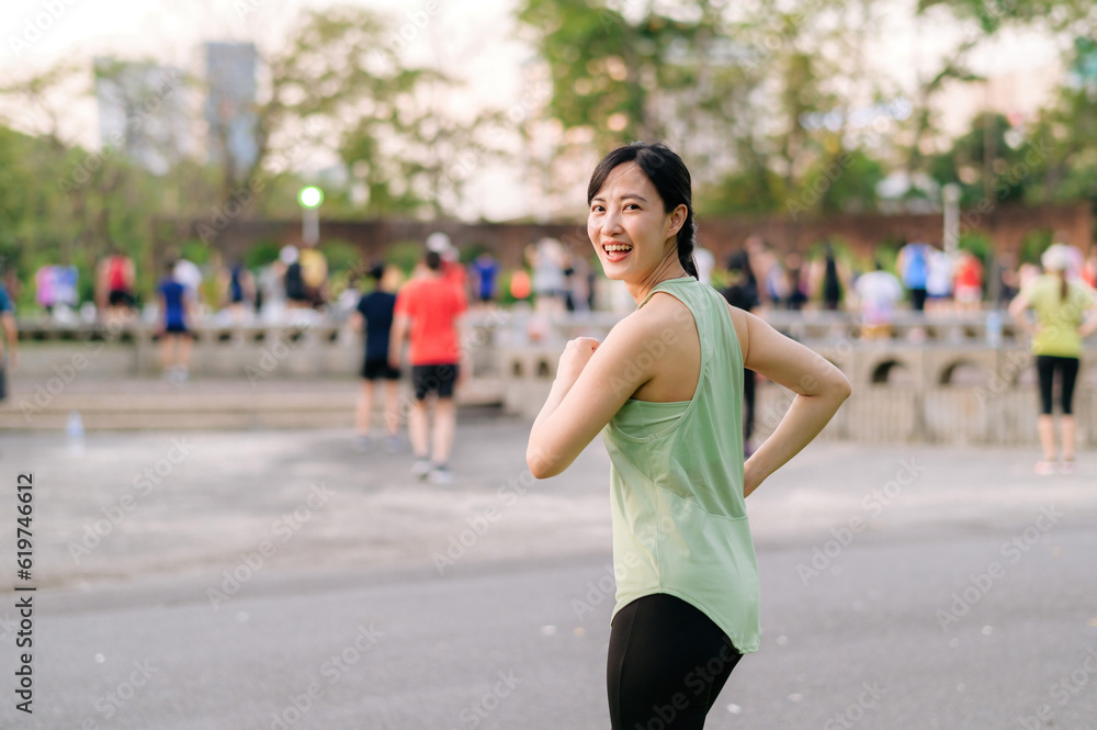 Female jogger. Fit young Asian woman with green sportswear aerobics dance exercise in park and enjoying a healthy outdoor. Fitness runner girl in public park. Wellness being concept Female jogger. Fit young Asian woman with green sportswear aerobics dance exercise in park and enjoying a healthy outdoor. Fitness runner girl in public park. Wellness being concept