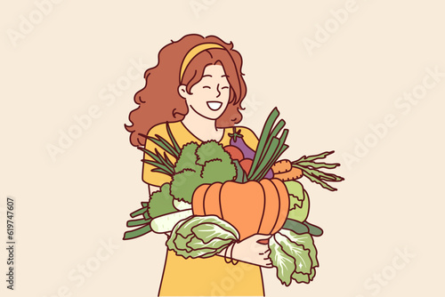 Woman with vegetables in hands rejoices good harvest or favorable prices for food at farmers market. Vegetarian girl holding organic vegetables for making healthy soups and tasty salts.