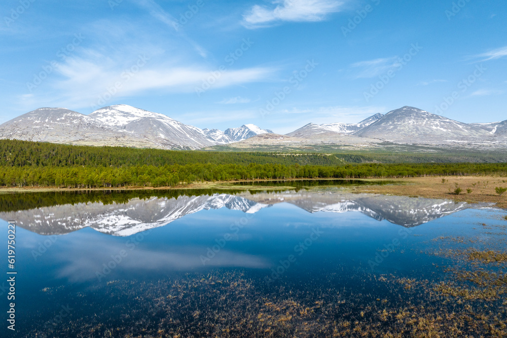 Mountain landscape with a reflection on a calm lake in Rondane National Park, Norway