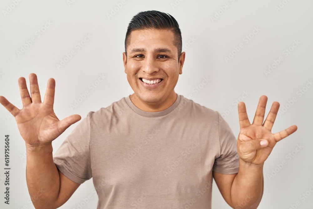 Hispanic young man standing over white background showing and pointing up with fingers number nine while smiling confident and happy. Hispanic young man standing over white background showing and pointing up with fingers number nine while smiling confident and happy.