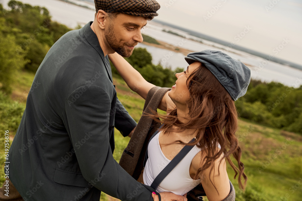 Cheerful and fashionable brunette woman in vintage suspenders and vest ...