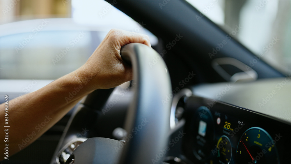 Middle age hispanic woman driving a car on the road