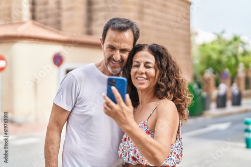 Man and woman couple smiling confident using smartphone at street