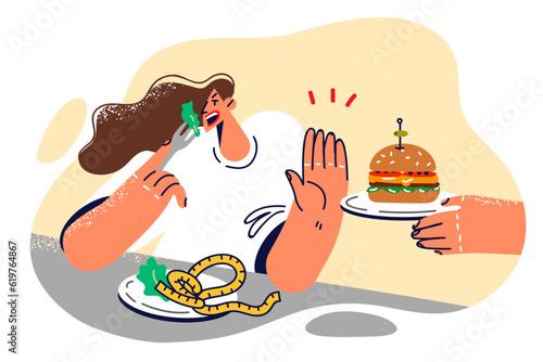 Woman refuses hamburger and eats healthy food, wanting to get rid of excess weight