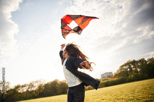 Obraz na płótnie Happy little girl is playing with kite on the summer field