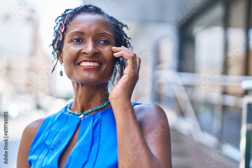 Middle age african american woman smiling confident talking on the smartphone at street