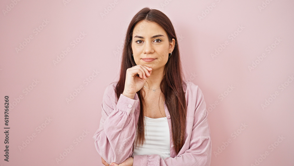Young beautiful hispanic woman standing with serious expression over isolated pink background Young beautiful hispanic woman standing with serious expression over isolated pink background