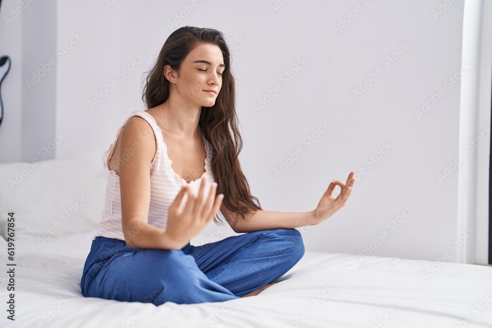 Young hispanic woman doing yoga exercise sitting on bed at bedroom Young hispanic woman doing yoga exercise sitting on bed at bedroom