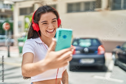 Young hispanic woman smiling confident having video call at street