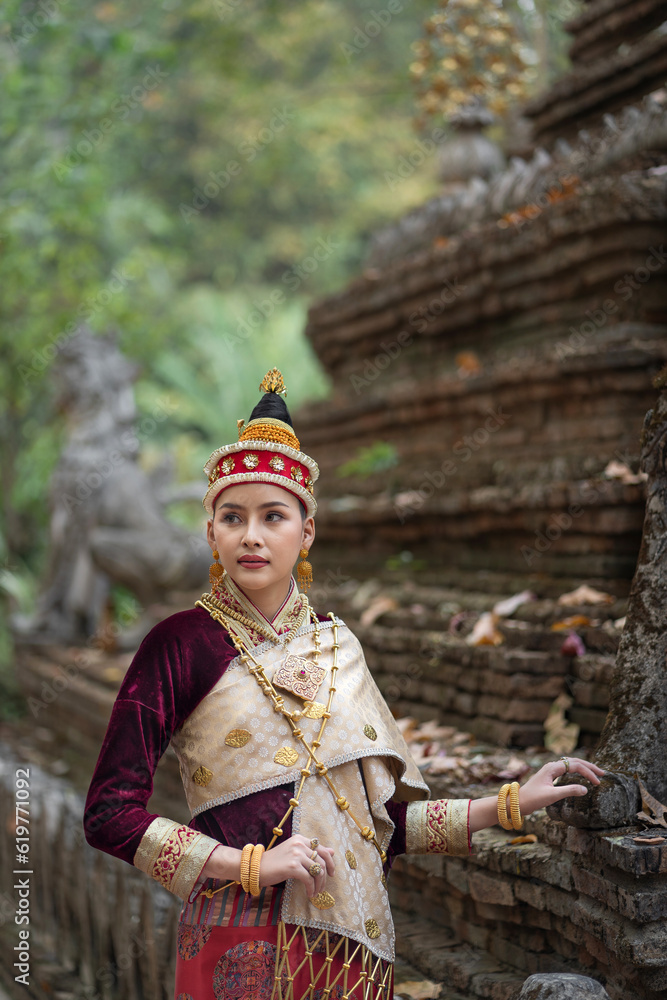 Obraz premium Beautiful Laos girl dressed in ancient luxury national traditional Laos clothes costume. Asian young woman wearing antique traditional Laos Luang Prabang elegantly ethnic clothes culture.