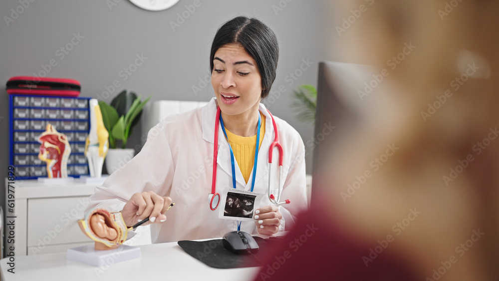 Fototapeta premium Young beautiful hispanic woman gynecologist having gynecology consultation with patient at clinic