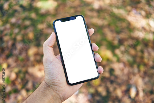 Man holding smartphone showing white blank screen at park