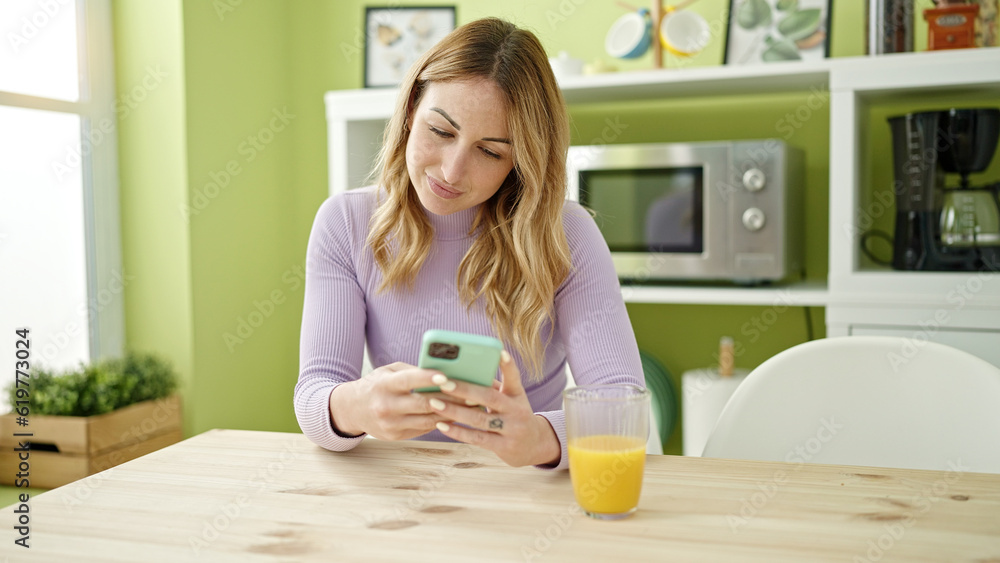 Young beautiful hispanic woman using smartphone sitting on the table at dinning room Young beautiful hispanic woman using smartphone sitting on the table at dinning room