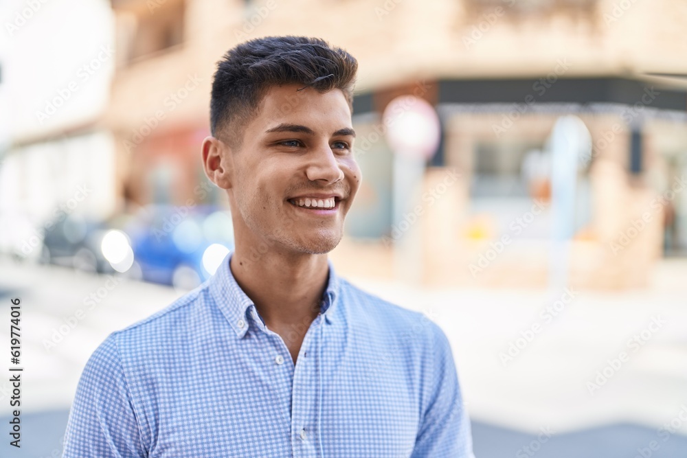 Obraz premium Young hispanic man smiling confident looking to the side at street
