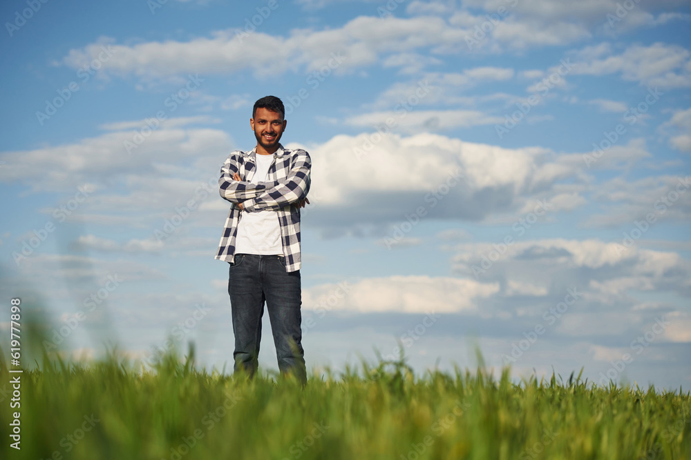 Cloudy sky on background. Handsome Indian man is on the agricultural field Cloudy sky on background. Handsome Indian man is on the agricultural field