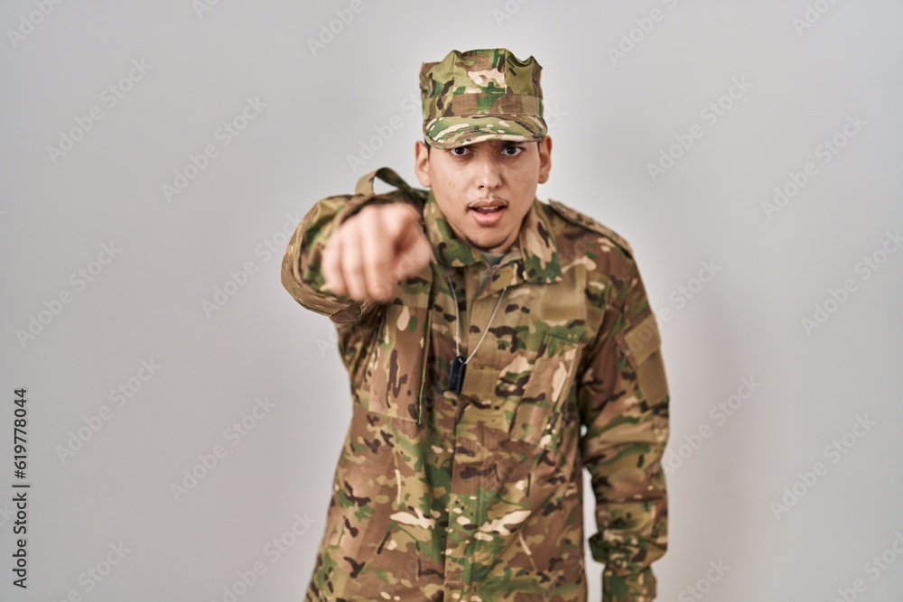 Young arab man wearing camouflage army uniform pointing displeased and frustrated to the camera, angry and furious with you Young arab man wearing camouflage army uniform pointing displeased and frustrated to the camera, angry and furious with you