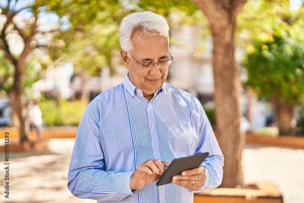Senior man smiling confident using touchpad at park Senior man smiling confident using touchpad at park