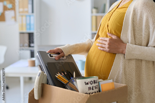 Tableau sur toile Close-up of pregnant busnesswoman packing her things in box before leaving her w