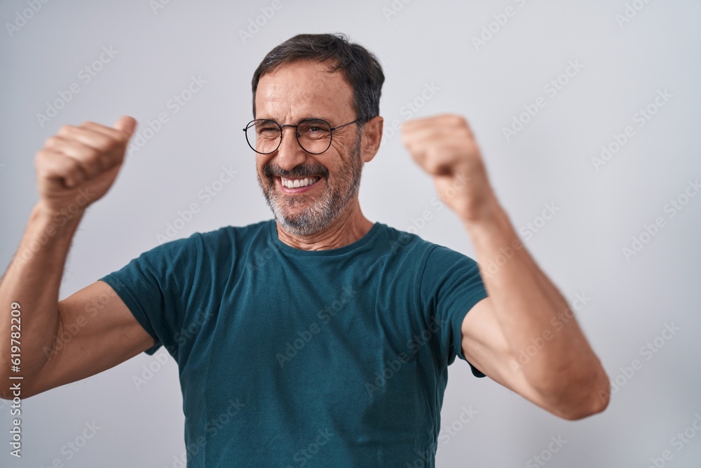 Middle age man standing with winner expression over isolated white background Middle age man standing with winner expression over isolated white background