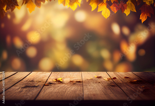 Beautiful autumn nature background with orange gold maple leaves on background of sunlight with soft blurred bokeh and empty wooden table planks