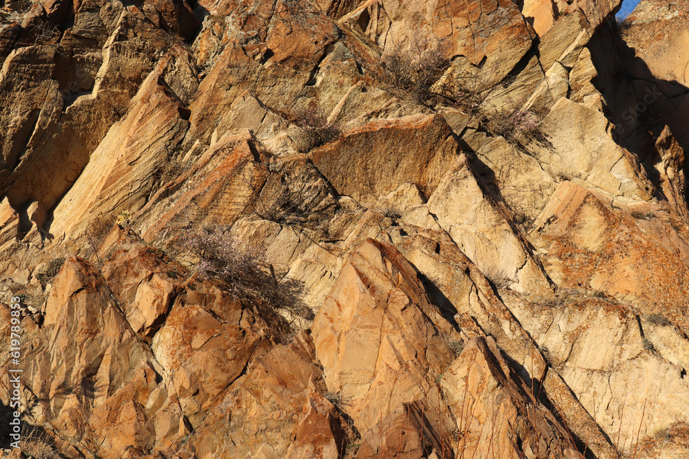Layered rocks and hills. Surface of a natural stone brown colour Layered rocks and hills. Surface of a natural stone brown colour