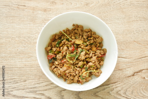 spicy stir fried chop pork with chili and basil leaf on bowl