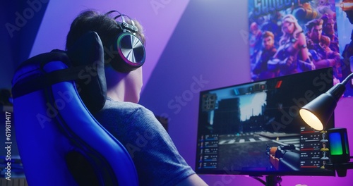 Fotografie Young gamer in headphones plays in first person shooter on computer and loses round in PvP multiplayer game