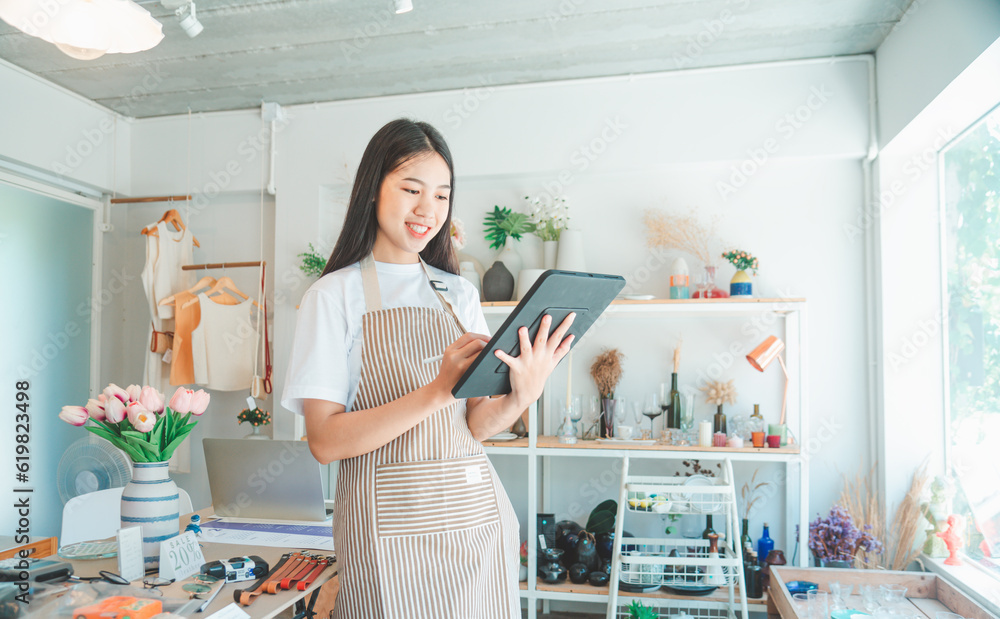 Small business owners are preparing a small shop and checking through a tablet and checking orders. Small business owners are preparing a small shop and checking through a tablet and checking orders.