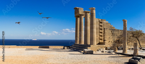 Acropolis of Lindos ancient city on Rhodes Island, Greece. Panoramic landscape with ruins the temple of Athena Lindia and view of the Aegean Sea at skyline.