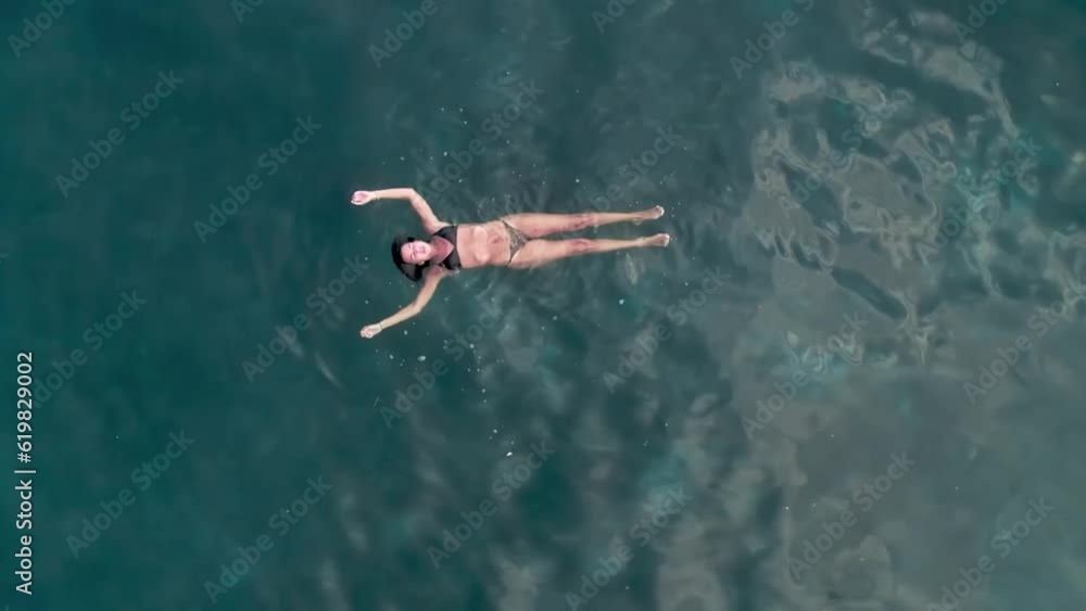 Aerial drone pull out of woman swimming in the ocean Aerial drone pull out of woman swimming in the ocean