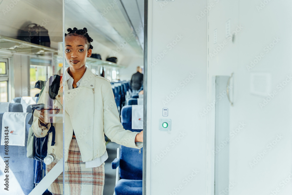 Lifestyle photo of thoughtful black woman come out while opening door to train. Portrait of female traveler In white jacket and plaid skirt with backpack on railway station. Lifestyle photo of thoughtful black woman come out while opening door to train. Portrait of female traveler In white jacket and plaid skirt with backpack on railway station.