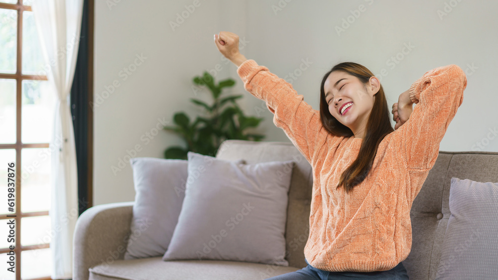Women raise arms to stretching and exercise while sitting on big sofa to relax in lifestyle at home Women raise arms to stretching and exercise while sitting on big sofa to relax in lifestyle at home