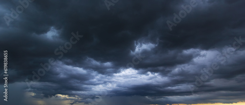 The dark sky with heavy clouds converging and a violent storm before the rain.Bad or moody weather sky and environment. carbon dioxide emissions, greenhouse effect, global warming, climate change. photo