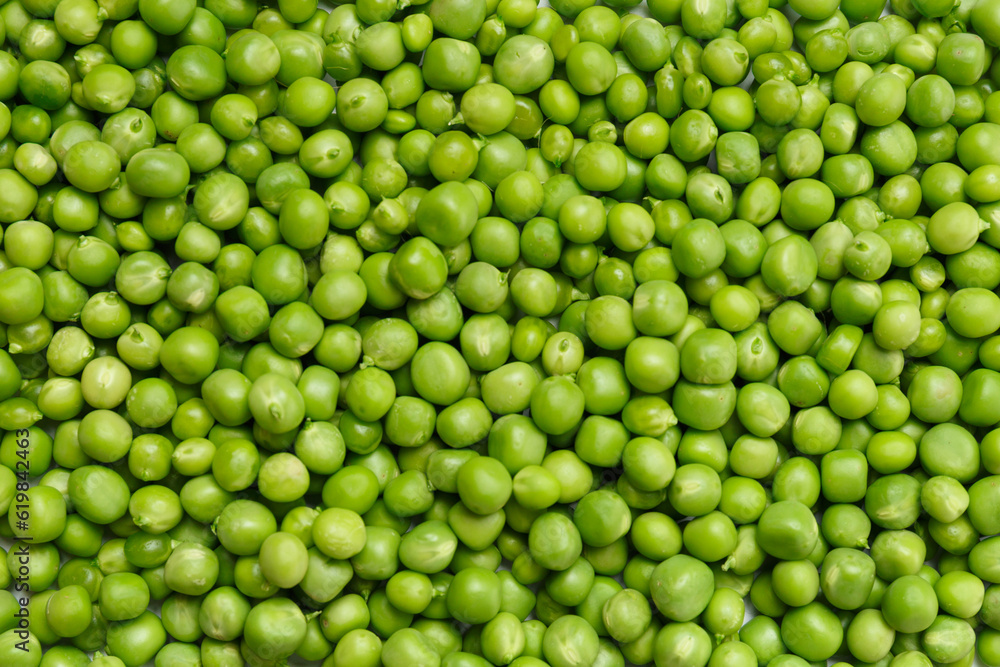 Background of fresh organic sweet green peas, pea grains close-up, top view.