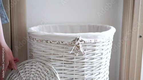 Female hand put clothes in laundry basket. High quality 4k footage photo