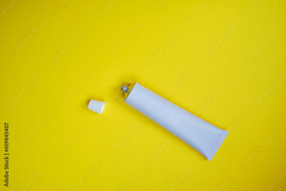 Stylish metal tube for drug or cosmetic branding - cream, gel, skin care, toothpaste. Container for cosmetic bottles on a colored background. Minimalism Stylish metal tube for drug or cosmetic branding - cream, gel, skin care, toothpaste. Container for cosmetic bottles on a colored background. Minimalism