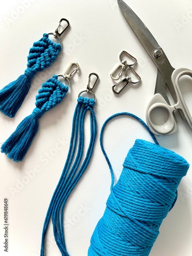 Weaving macrame. Materials for macrame. Blue cord, metal carabiners, scissors. Close-up on a white background