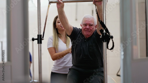 Female Physiotherapist Assisting Senior Man on Pilates Machine
