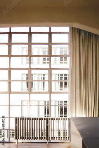 vista frontal de un ventanal de acero con cortinas y un radiador