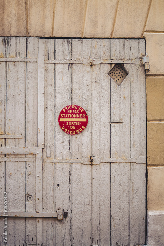 puerta de madera envejecida con placa roja redonda