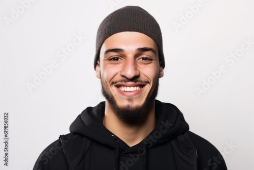 Portrait of a smiling young man in a black hoodie on a white background