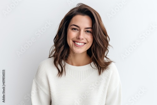 Medium shot portrait photography of a grinning woman in her 30s wearing a cozy sweater against a white background © Hanne Bauer