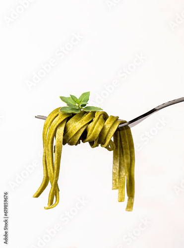 Macro food photography of pasta, linguine, fettuccine, trenette, spinach, oregano, durum, wheat, semolina, fork, background, italian