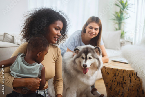 family LGBT diversity lesbian couple with her boy and dog in room. LGBT lifestyle